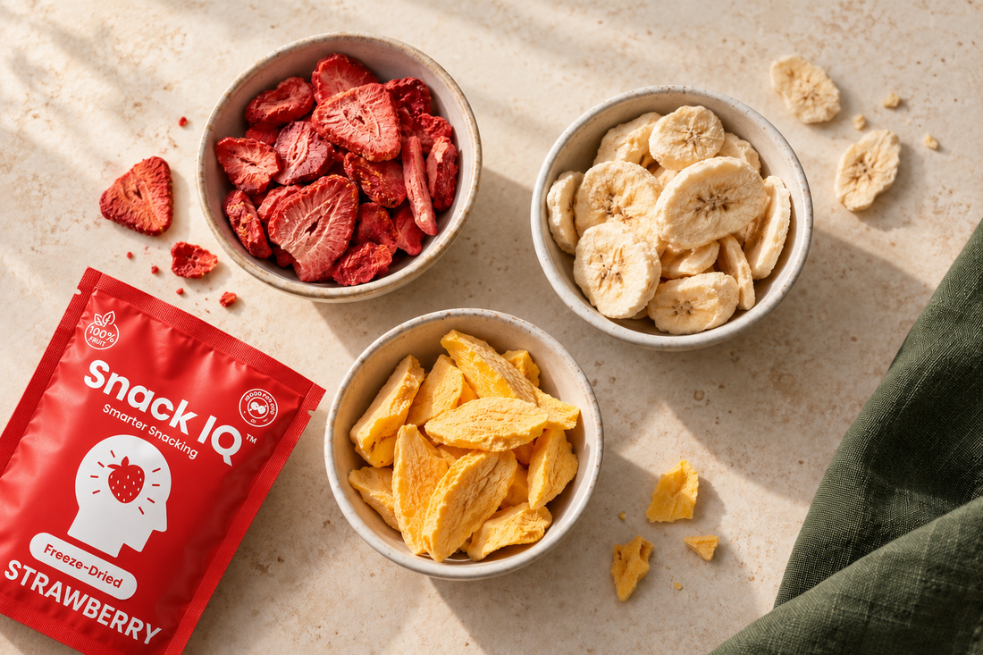 Snack IQ strawberry pouch beside bowls of freeze-dried strawberries, bananas and mango
